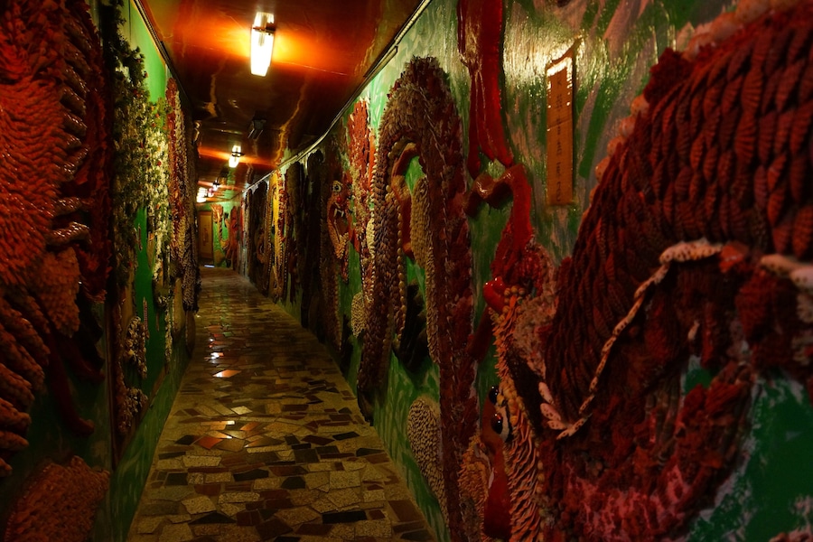 A corridor with patterned walls and a tiled floor.