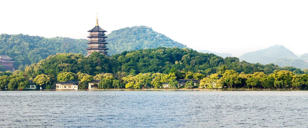 A pagoda on a lush green island surrounded by water.