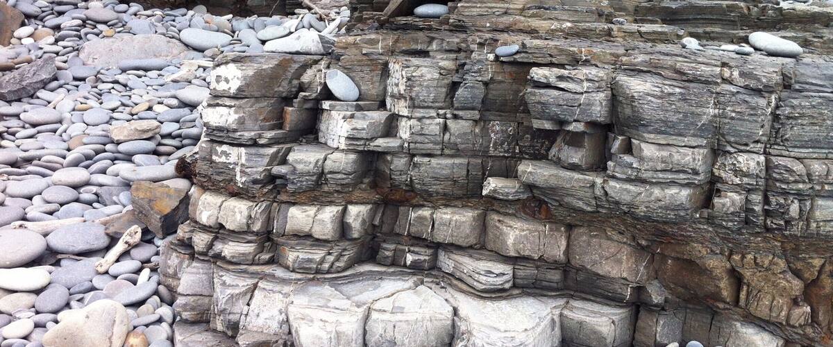 A rocky formation with stacked stones and a cave entrance.