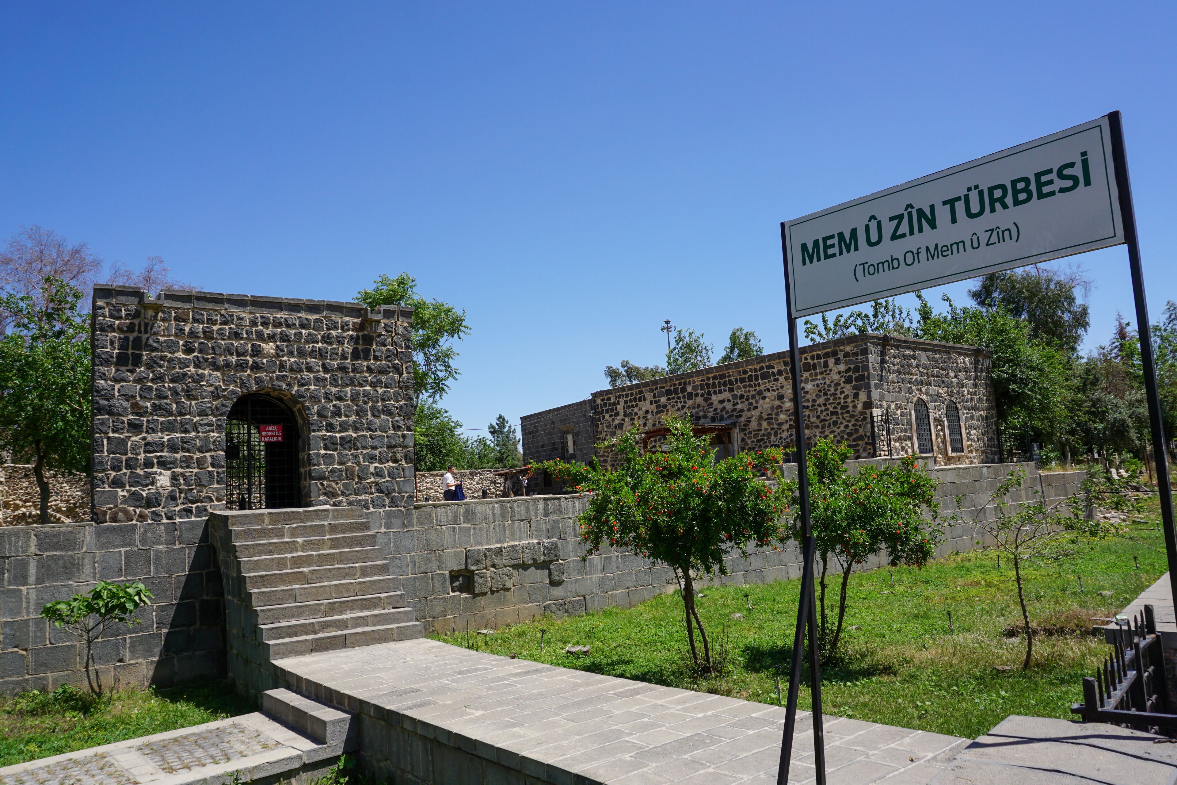 A stone building with a sign reading "MEM ÖZİN TÜRBESİ (Tomb Of Mem Özün)".