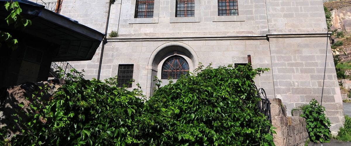 A historic building with a prominent minaret, arched windows, and a dome.