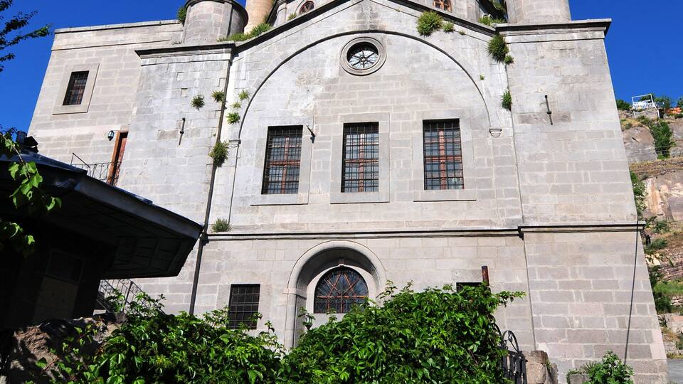 A historic building with a prominent minaret, arched windows, and a dome.