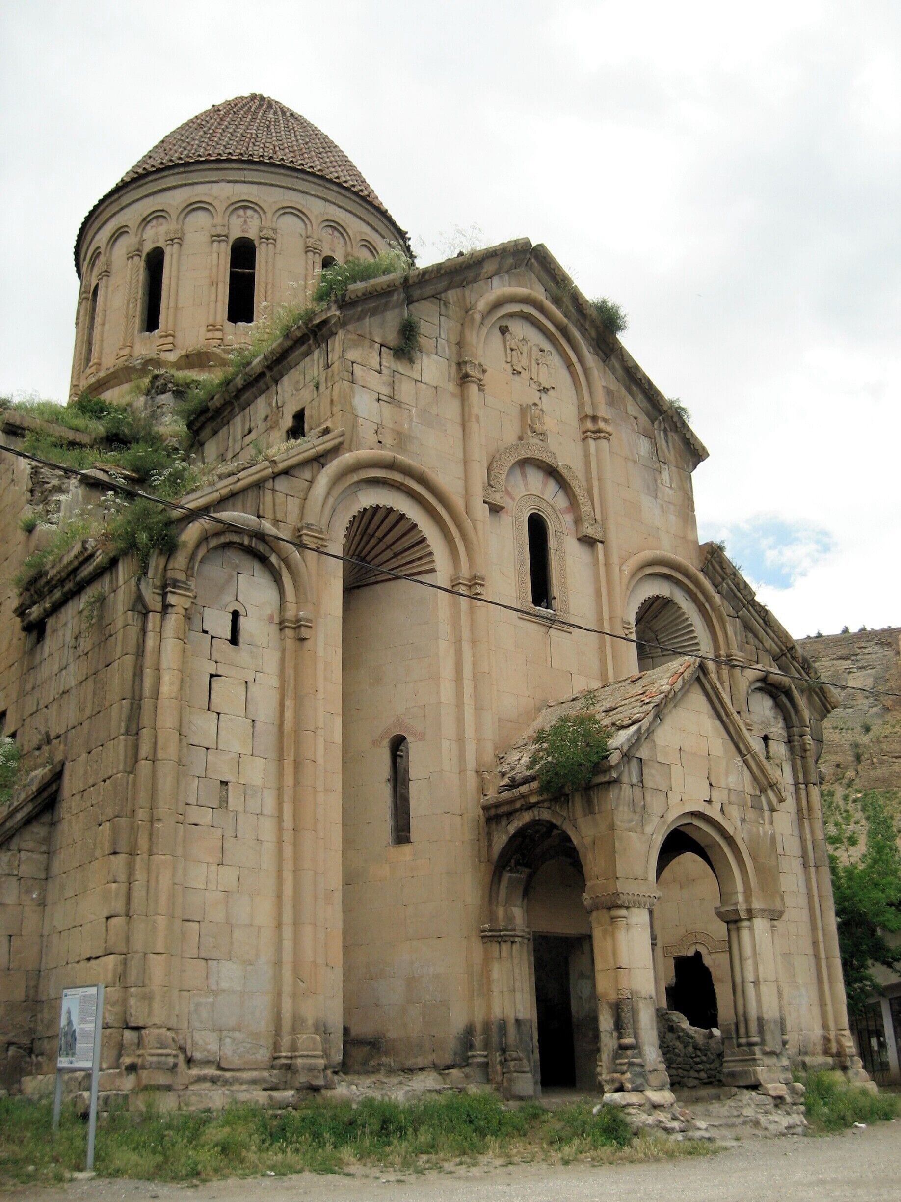A historic stone church with a dome, arched windows, and a bell tower.