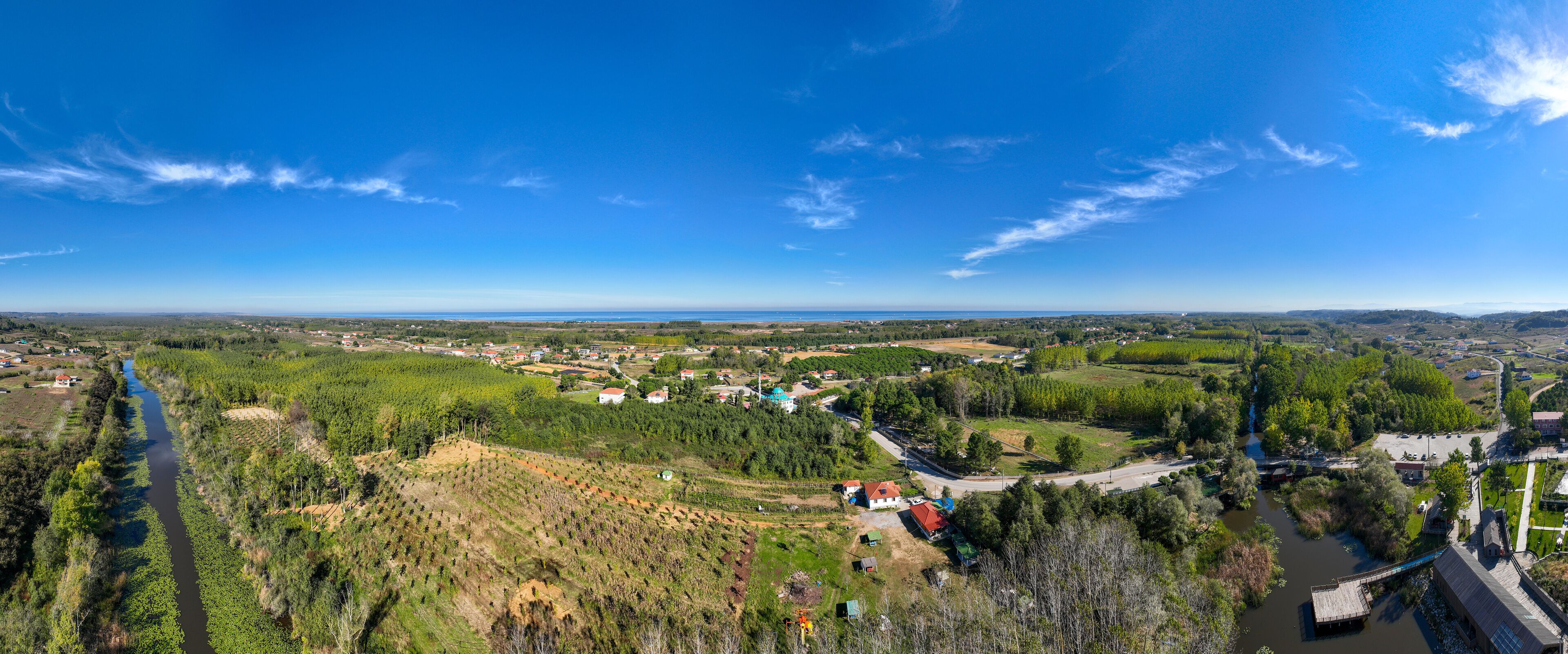 A river winding through a valley with scattered houses and a bridge.