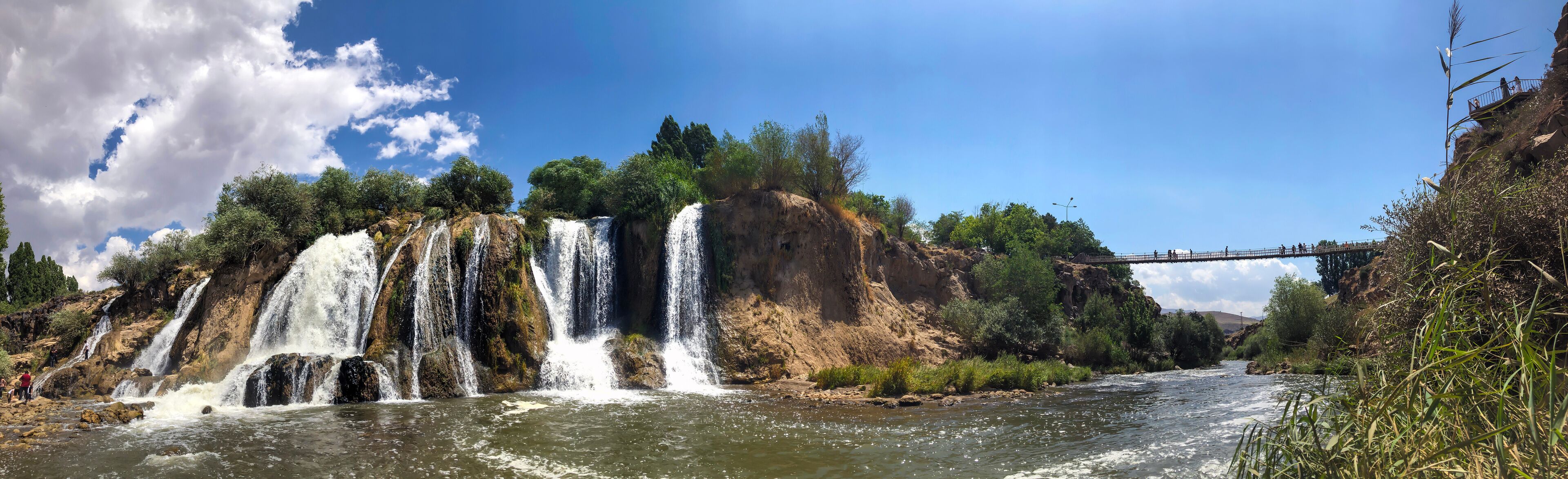muradiye waterfall, van province turkey. open air view of trees and exuberant waterfall.
