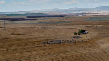 Great nature view, freshly mown crops and foggy mountains with clouds in the background. Emirdag, Turkey.