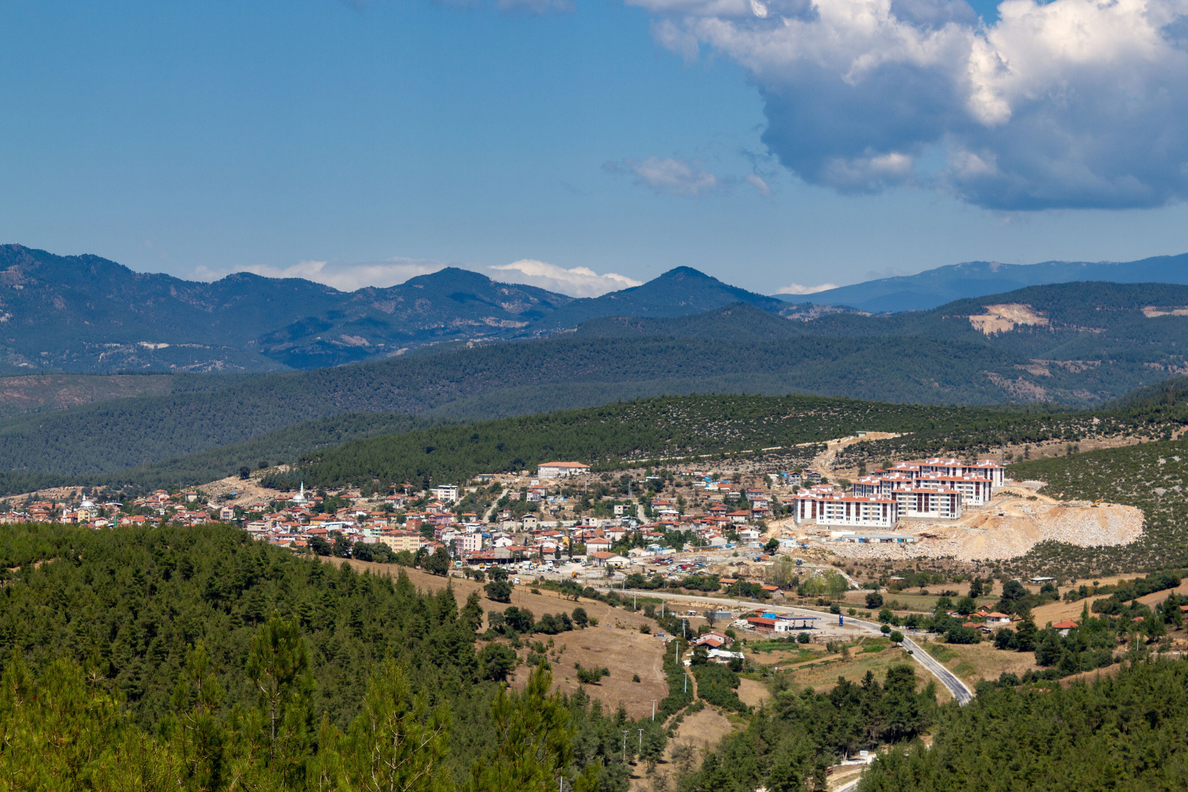 A town nestled in a valley with mountains in the background.