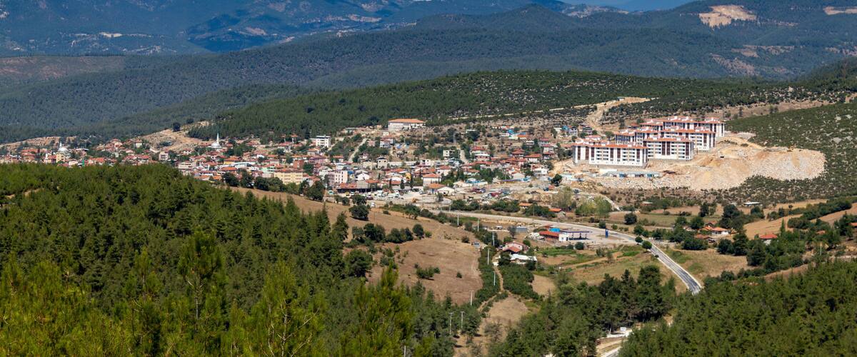A town nestled in a valley with mountains in the background.