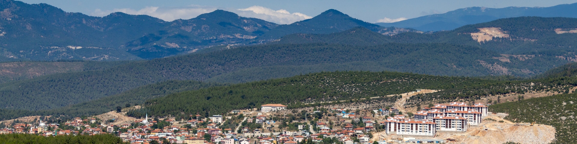 A town nestled in a valley with mountains in the background.