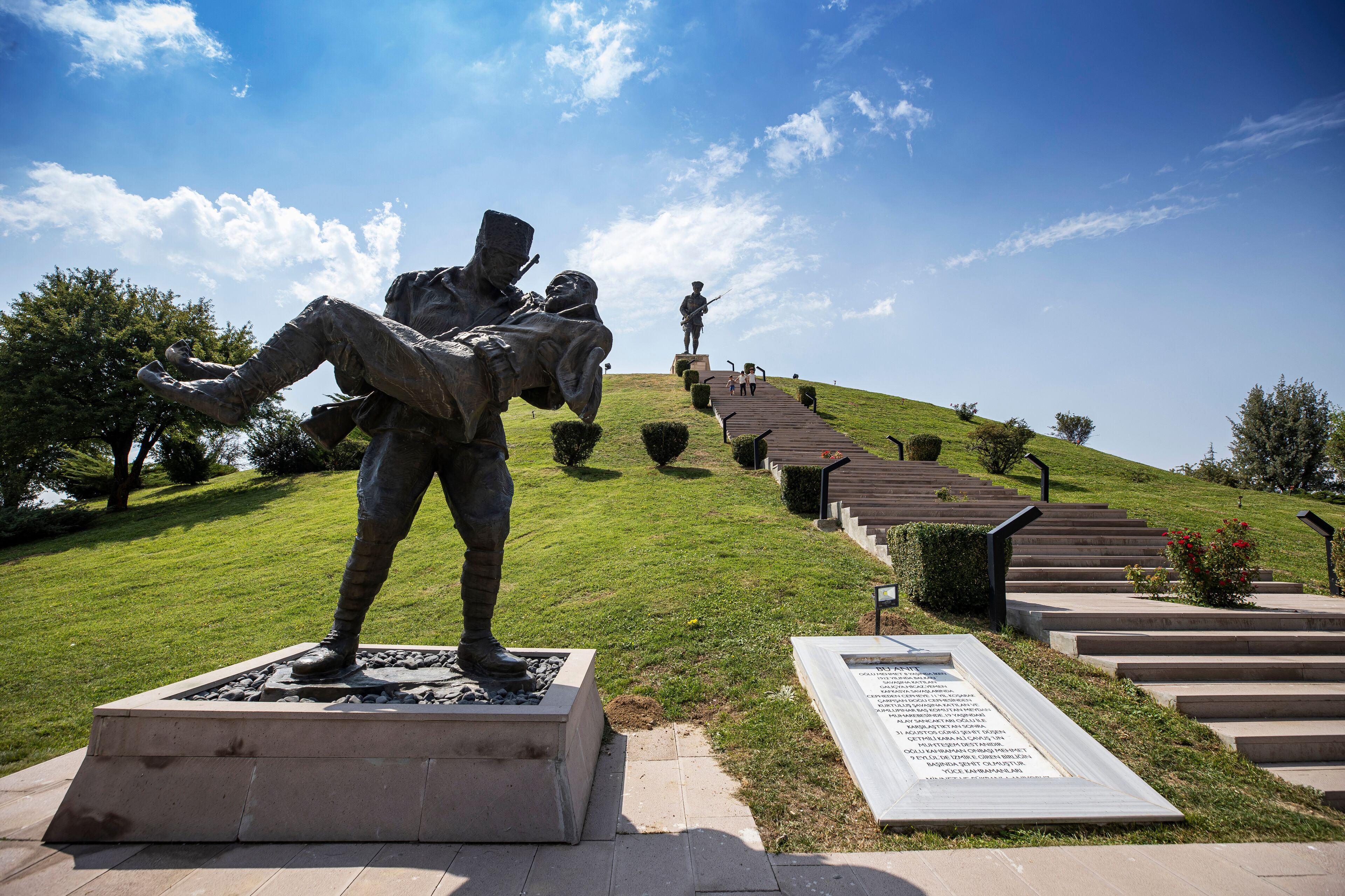A statue of a soldier on a hill with a staircase leading up to it.