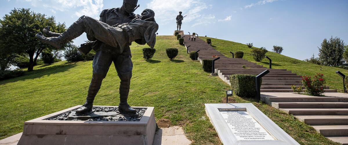 A statue of a soldier on a hill with a staircase leading up to it.