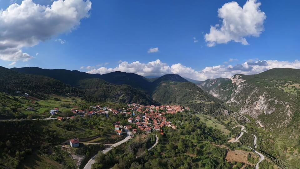 A mountainous landscape with a village nestled in the valley.