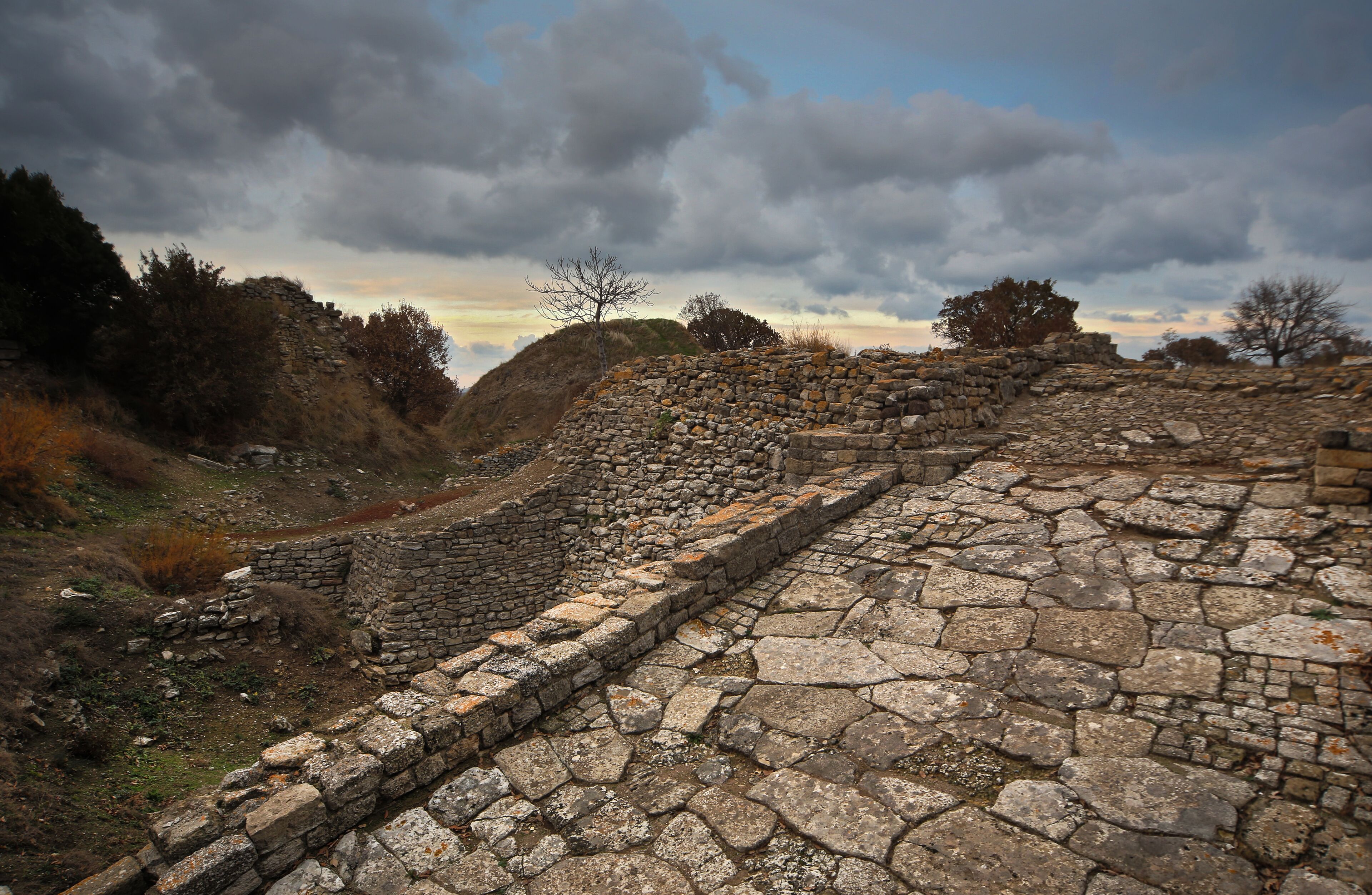 Ancient stone ruins with a stone wall and a pathway.