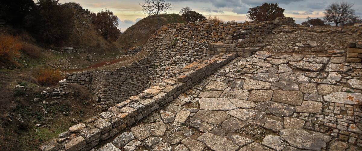 Ancient stone ruins with a stone wall and a pathway.