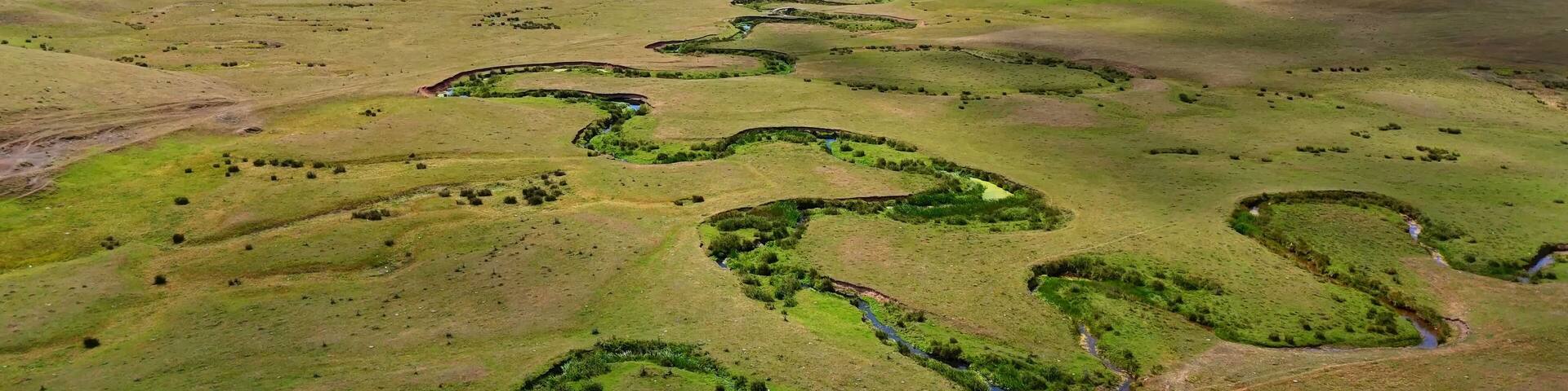 The Perşembe Yaylası is the summer pastureland of Perşembe district. Panoramic View of Meandering Stream and Majestic Mountains in Perşembe Plateau, Ordu, Turkiye.