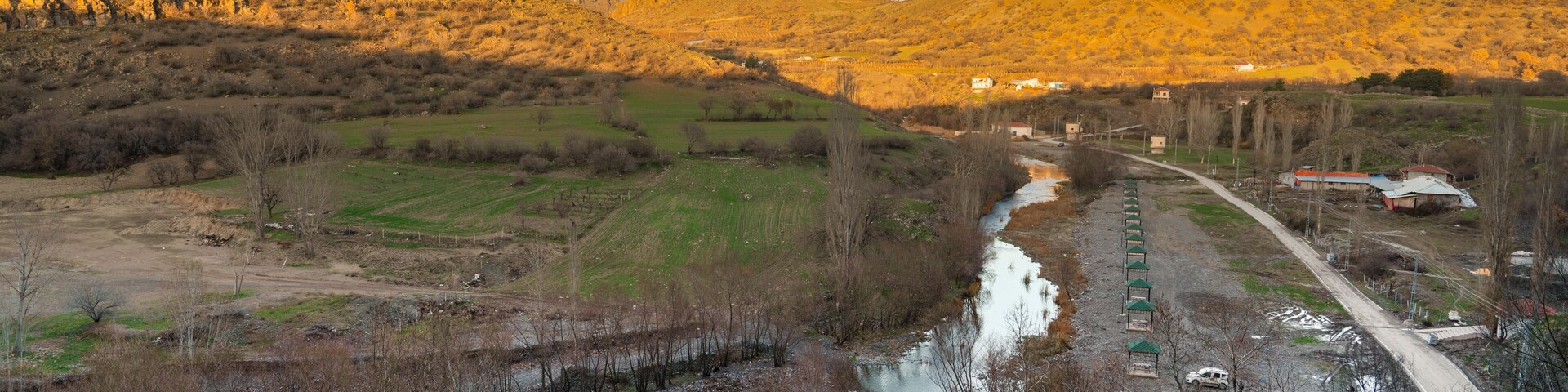 Un río serpentea por un valle, con montañas al fondo.