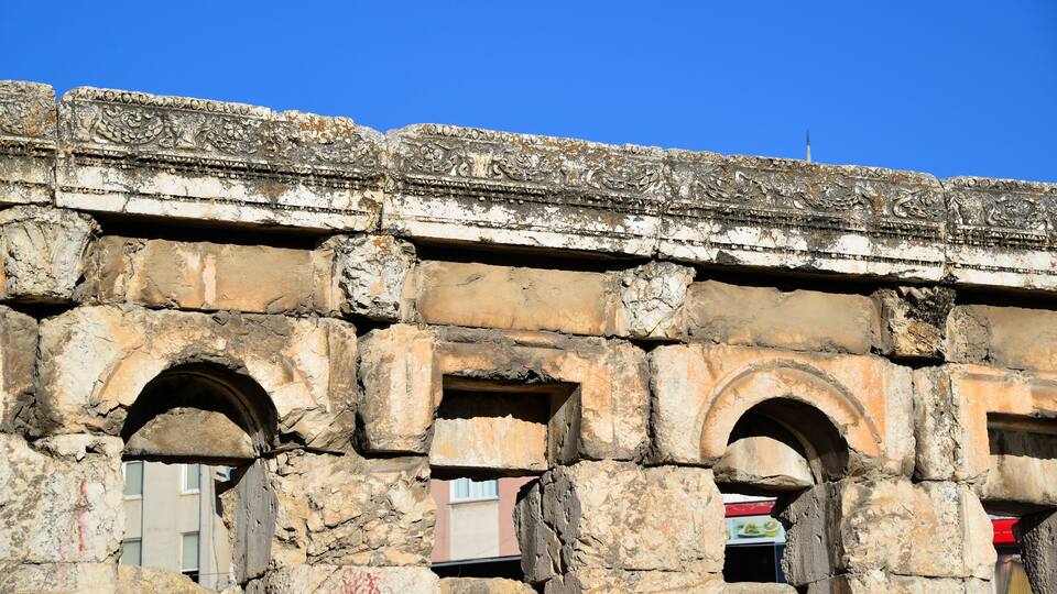 Ancient stone architecture with carved decorations and arched doorways.