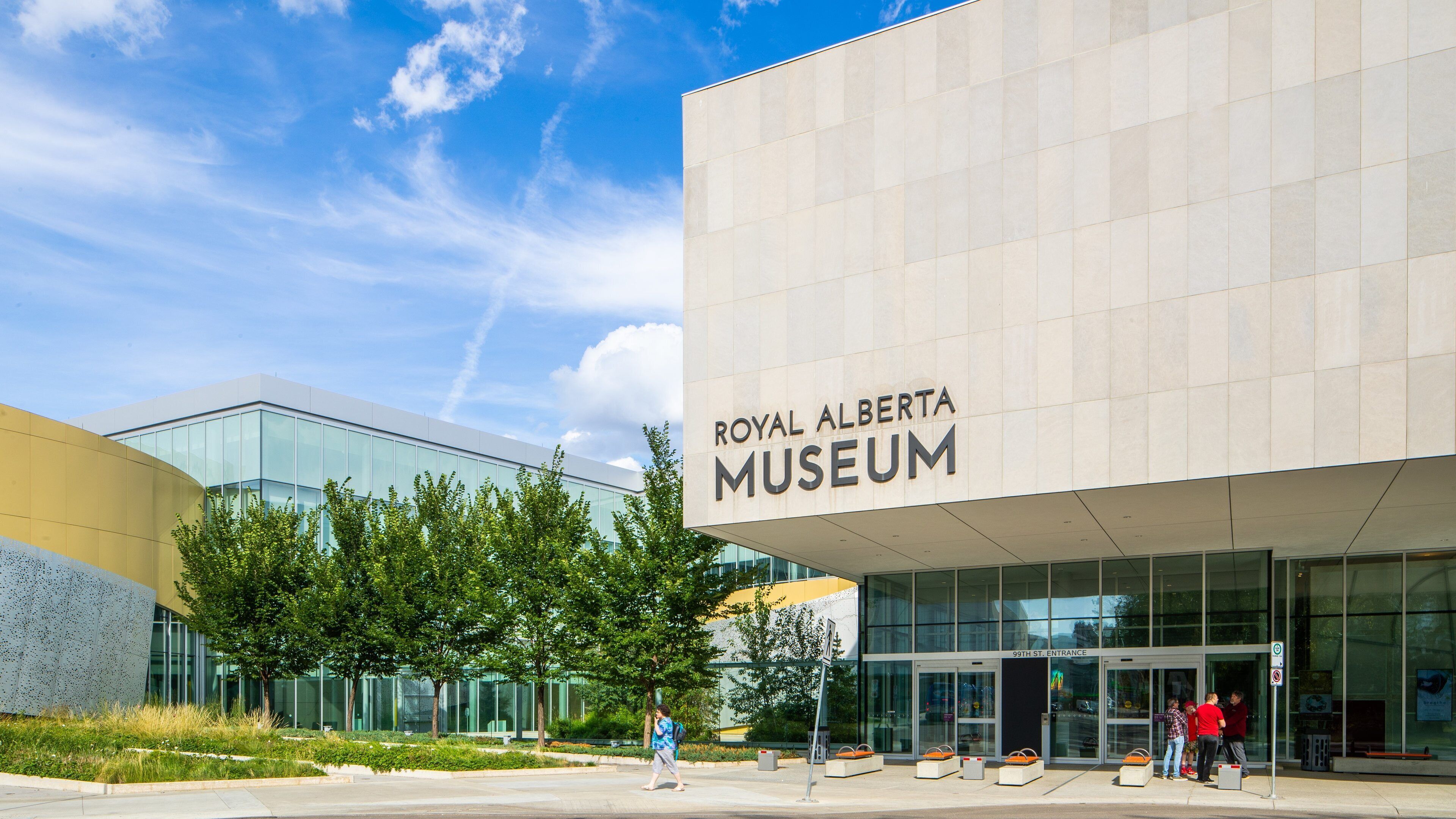 The Royal Alberta Museum entrance with glass doors and a clear blue sky.