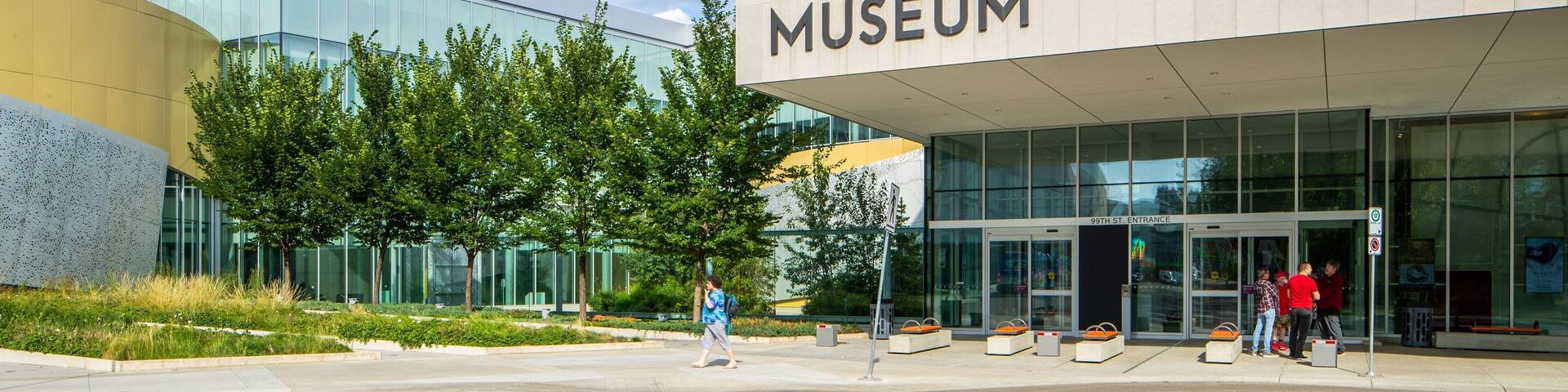 The Royal Alberta Museum entrance with glass doors and a clear blue sky.
