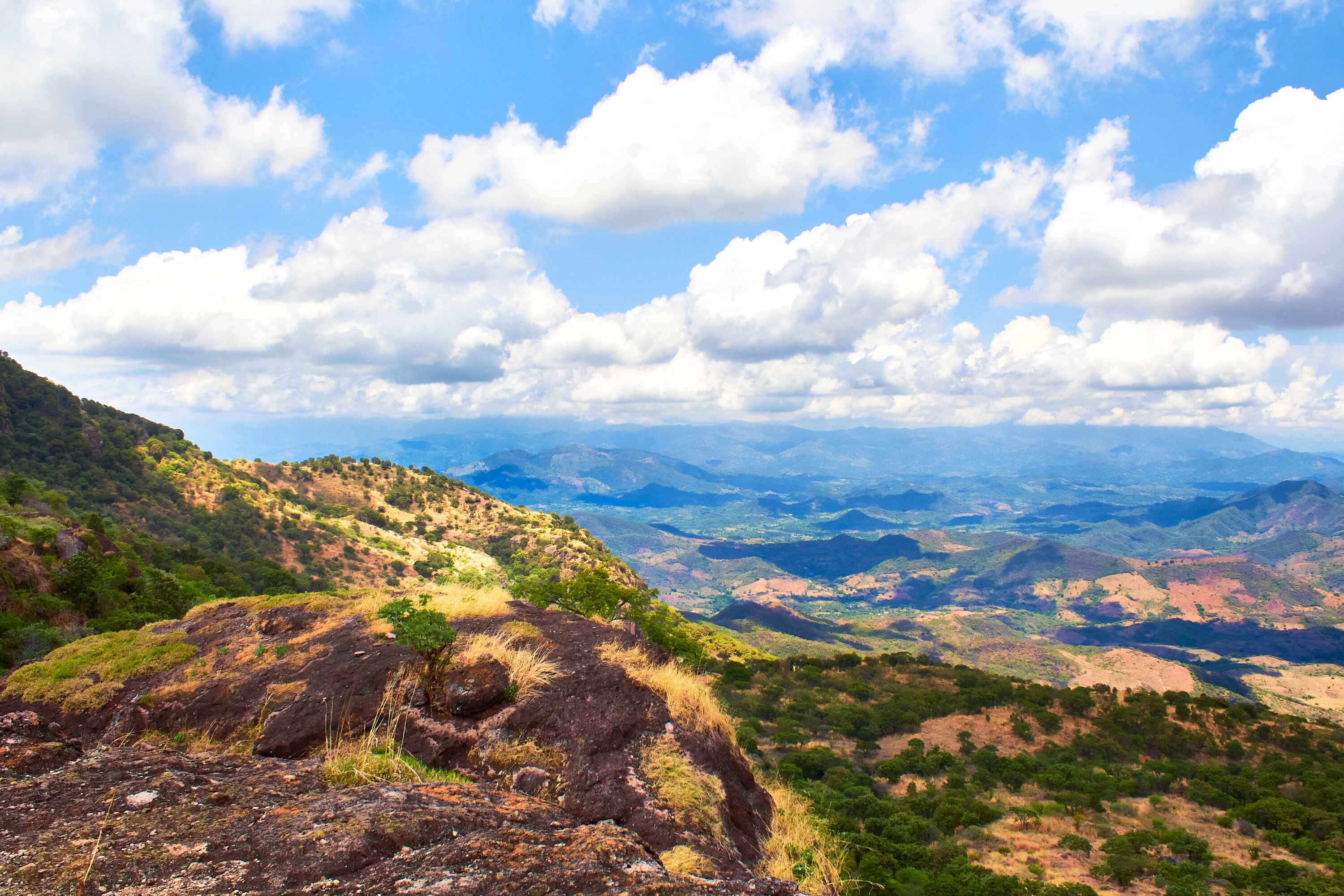 paisaje rural deforestado visto desde lo alto de una montaña en un día soleado con nubes en el cielo sierra en el fondo 
