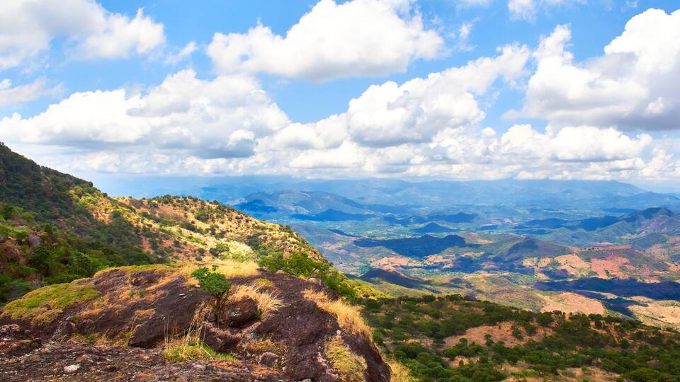 paisaje rural deforestado visto desde lo alto de una montaña en un día soleado con nubes en el cielo sierra en el fondo