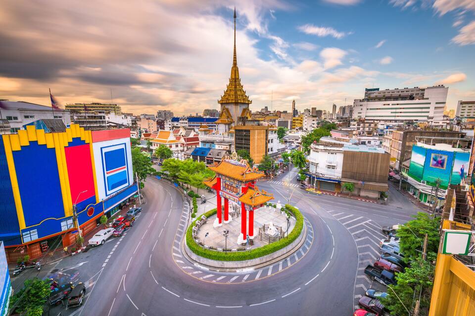 Paisagem urbana com um círculo de rotatórias, um templo tradicional e edifícios modernos.