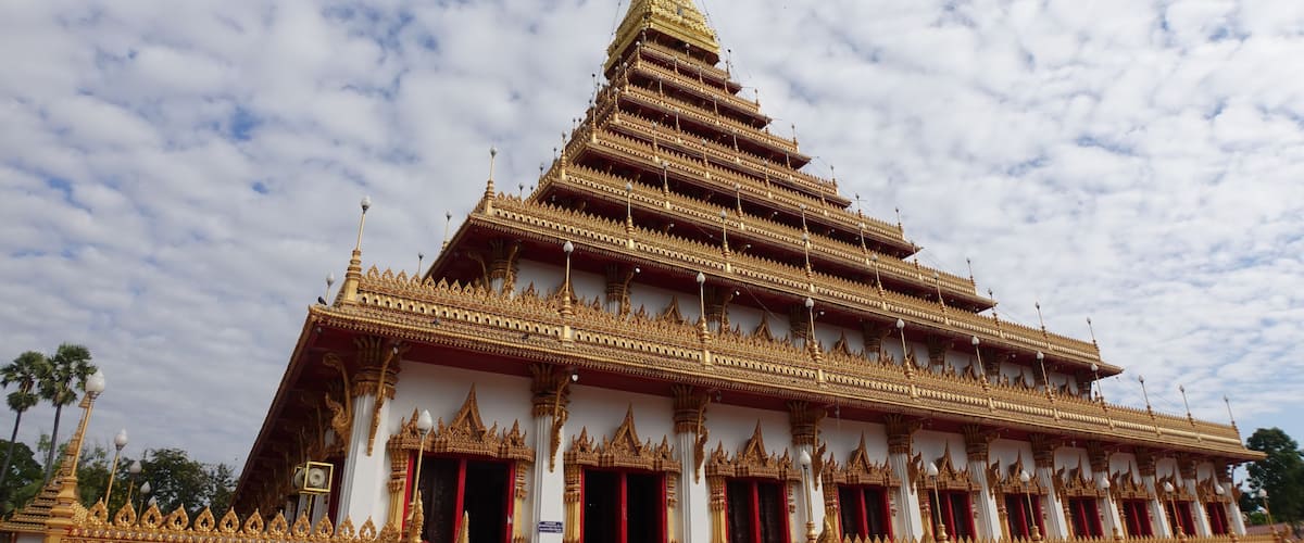 Ein mehrstufiger Tempel mit aufwendigen, goldenen Verzierungen und einer weißen Fassade.
