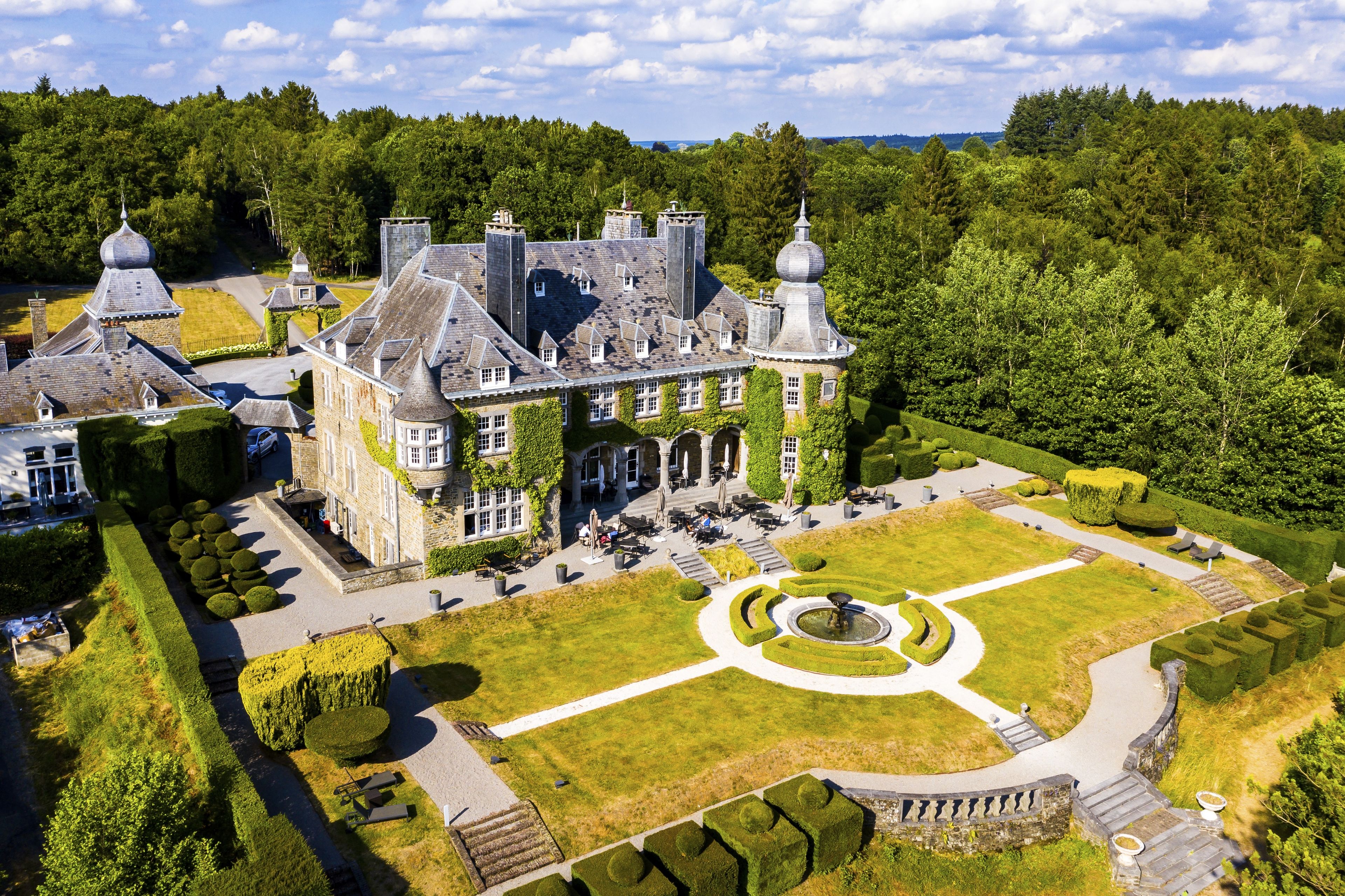 A large estate with a formal garden, a central fountain, and multiple buildings with distinctive architecture.