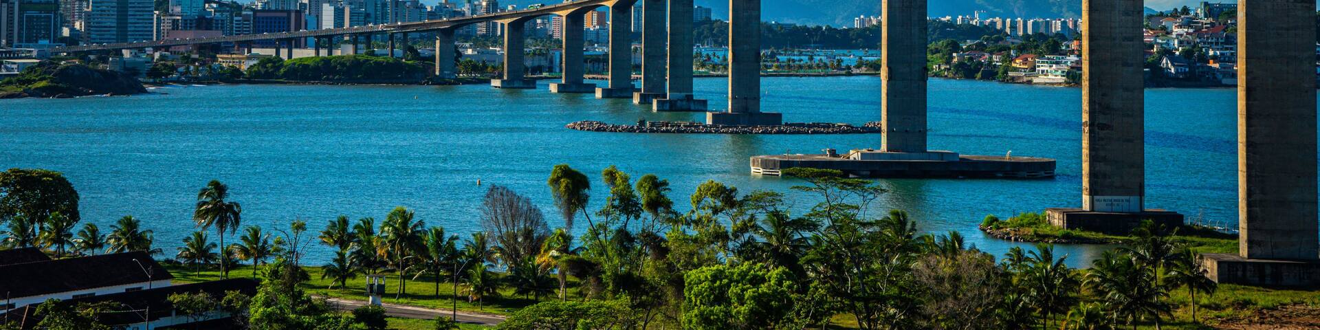 A bridge over a body of water with a cityscape in the background.