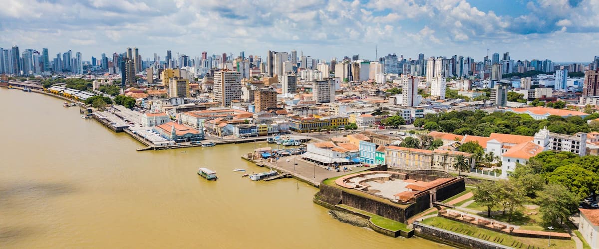 Un río con barcos, un paisaje urbano con edificios históricos y un horizonte moderno.