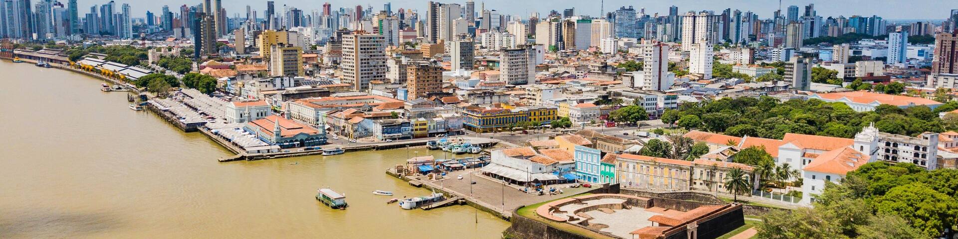 A river with boats, a cityscape with historic buildings, and a modern skyline.
