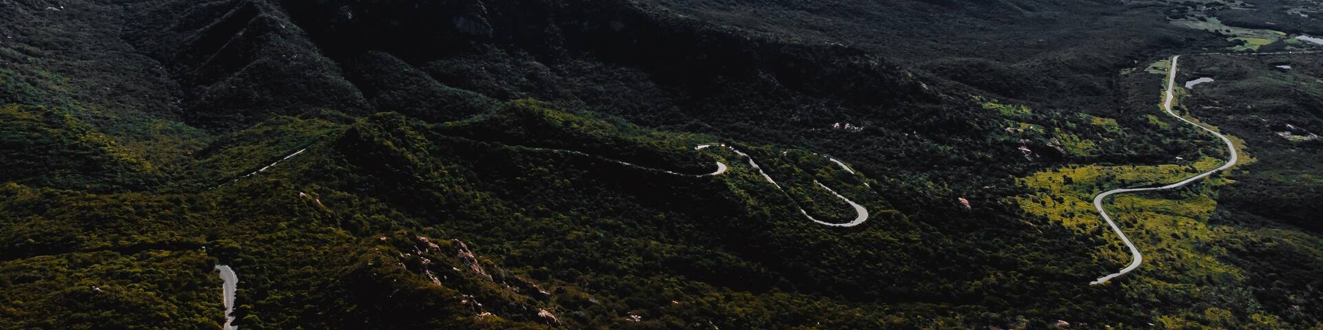 A mountainous landscape with winding roads and a river.