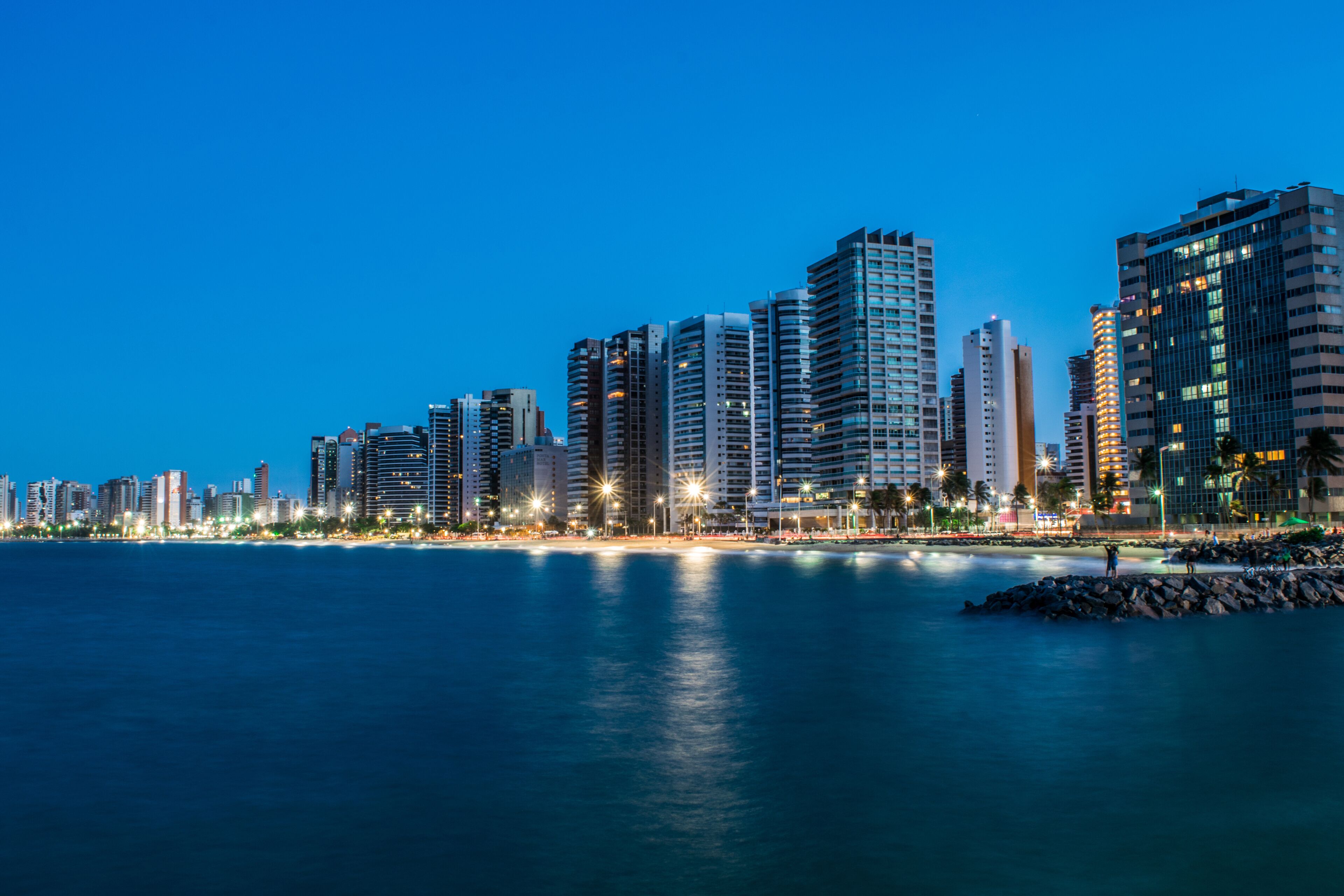 Un horizonte urbano al atardecer, con rascacielos a lo largo de una costa.