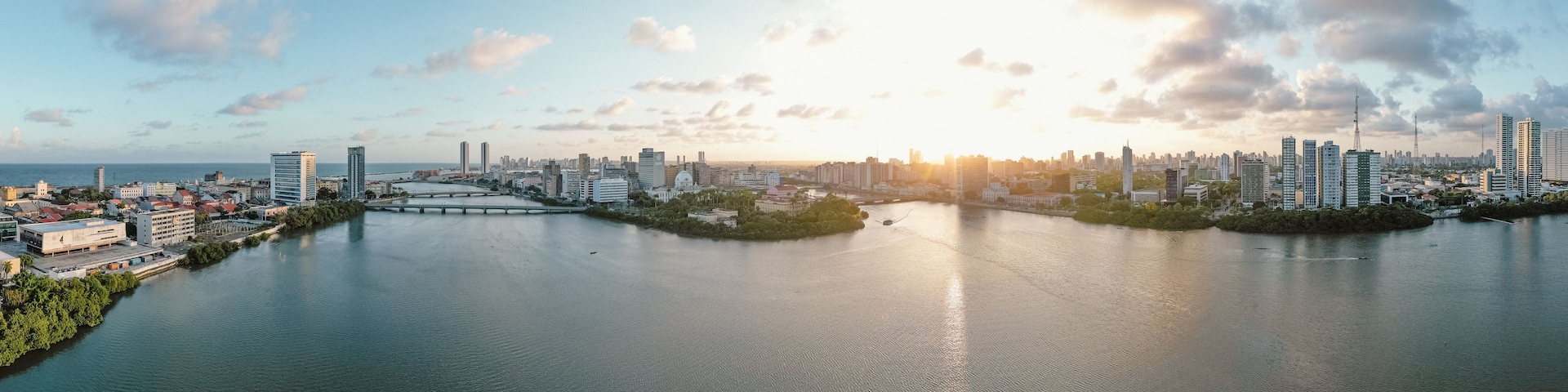 Un paisaje urbano con un río, puentes y un atardecer.