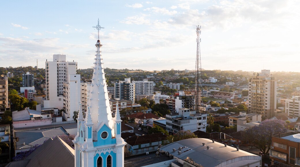 A cityscape with a prominent church spire, high-rise buildings, and a clear sky.