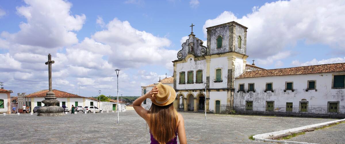 Tourism in Brazil. Panoramic view of tourist woman visiting Sao Francisco Square in Sao Cristovao town, Sergipe, UNESCO World Heritage, Brazil.