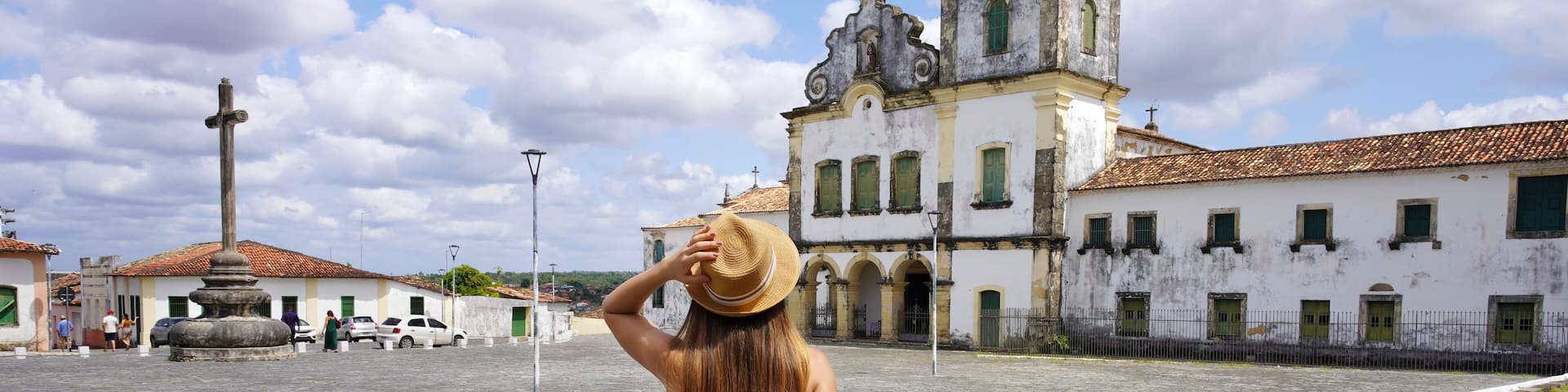 Tourism in Brazil. Panoramic view of tourist woman visiting Sao Francisco Square in Sao Cristovao town, Sergipe, UNESCO World Heritage, Brazil.