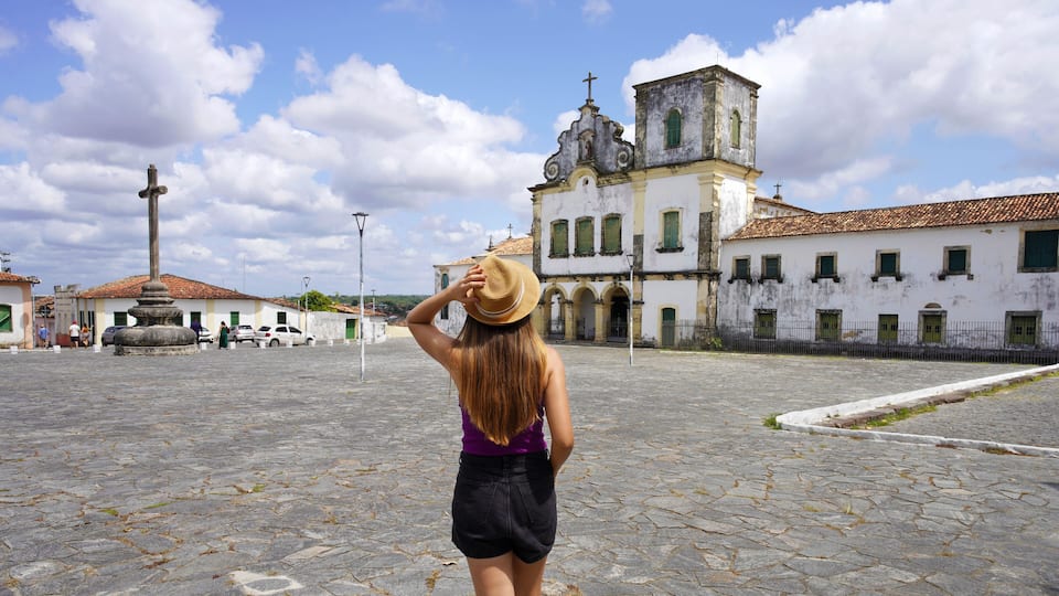 Tourism in Brazil. Panoramic view of tourist woman visiting Sao Francisco Square in Sao Cristovao town, Sergipe, UNESCO World Heritage, Brazil.