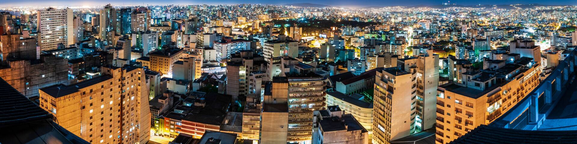 Panorama skyview of Porto Alegre city during the night with airplane trail in the sky, Rio Grande do Sul, Brazil