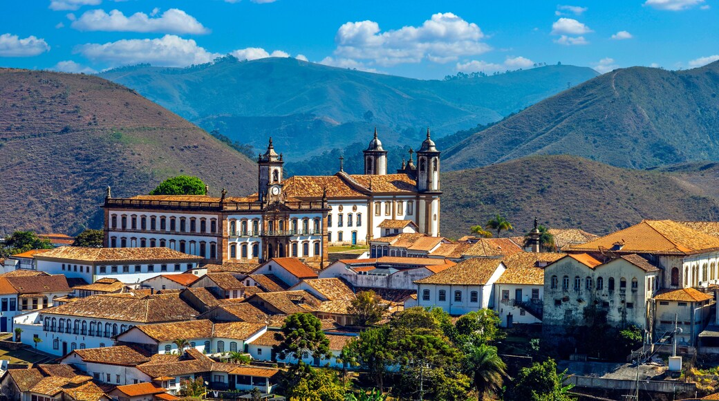 Panoramic view of the historic center of Ouro Preto, Minas Gerais, Brazil. Featuring colonial architecture, baroque churches, and red-tiled roofs against a stunning backdrop mountains.