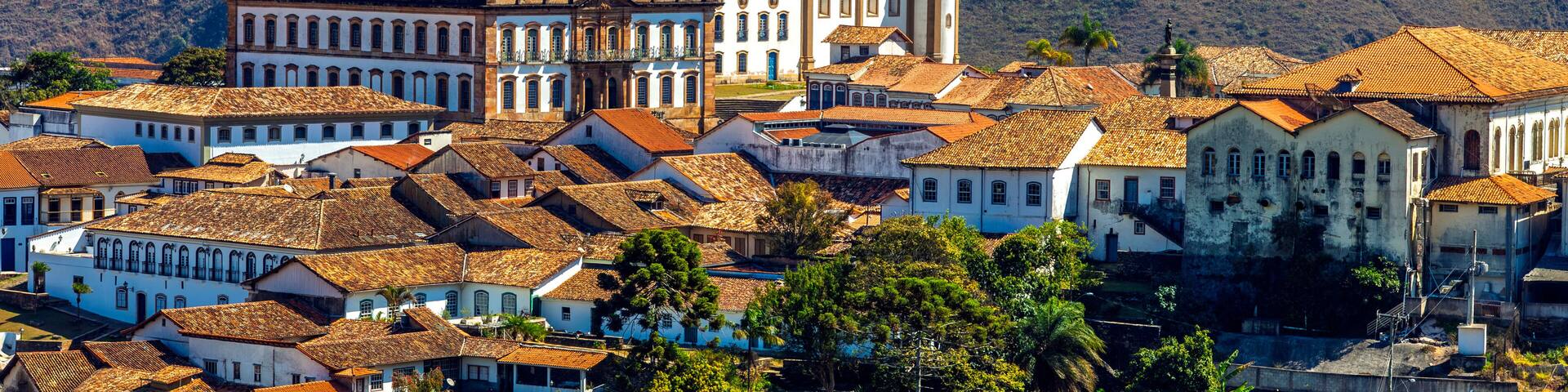 Panoramic view of the historic center of Ouro Preto, Minas Gerais, Brazil. Featuring colonial architecture, baroque churches, and red-tiled roofs against a stunning backdrop mountains.