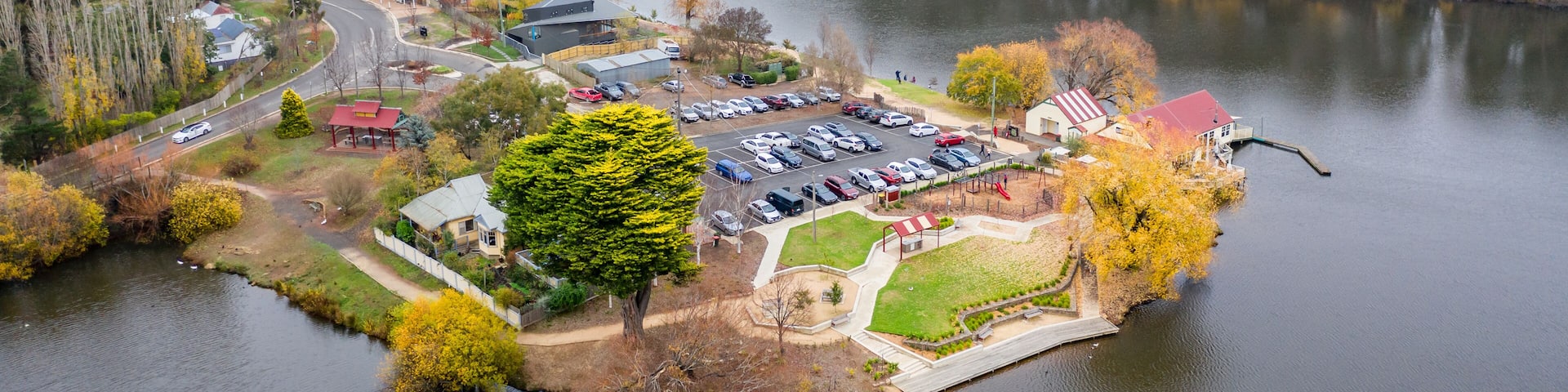 An aerial view of a lakeside community with a parking lot, buildings, and a dock.