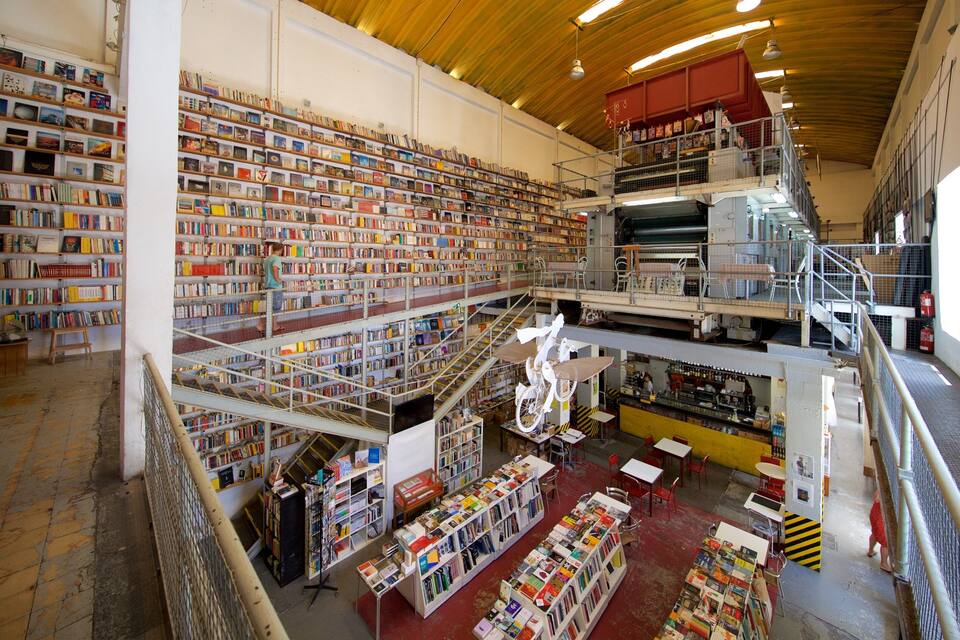A large, multi-level bookstore with extensive book collections on shelves and tables.