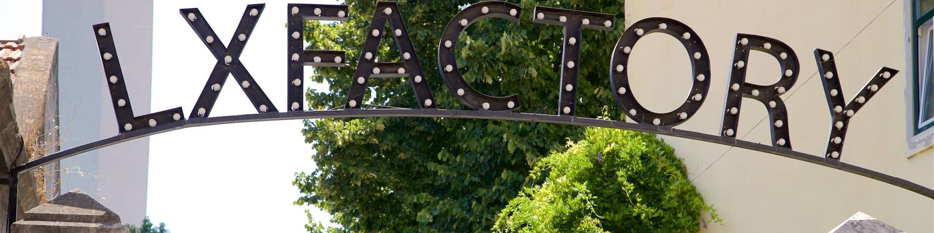 A metal sign with the word "LXFATORY" in large letters, mounted on a curved structure.