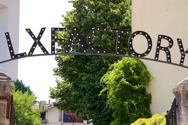 Une plaque métallique portant le mot « LXFATORY » en grandes lettres, fixée sur une structure incurvée.