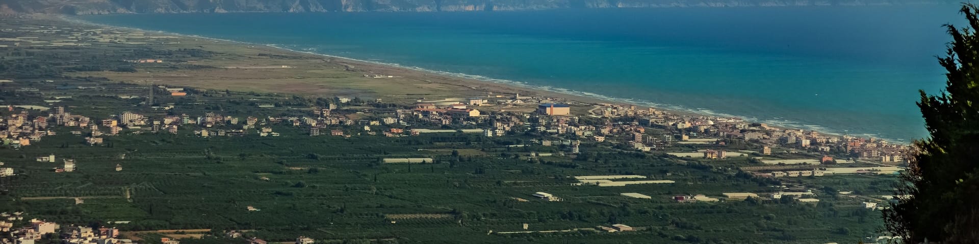 A coastal town with a mountain in the background.