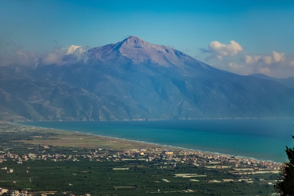 A coastal town with a mountain in the background.