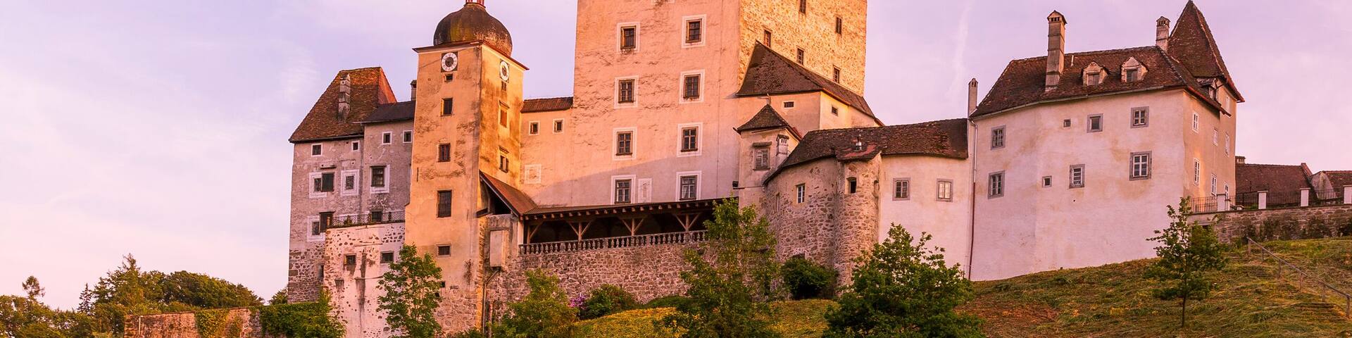 A castle on a grassy hill with a clear sky.