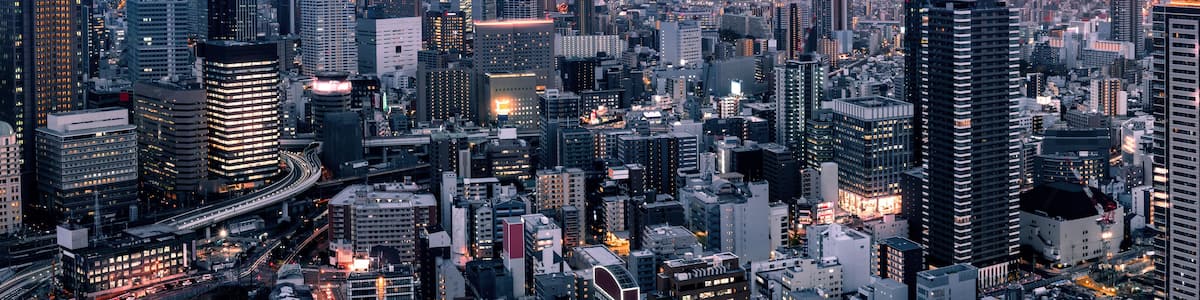 A densely packed urban skyline with numerous high-rise buildings and a network of roads.