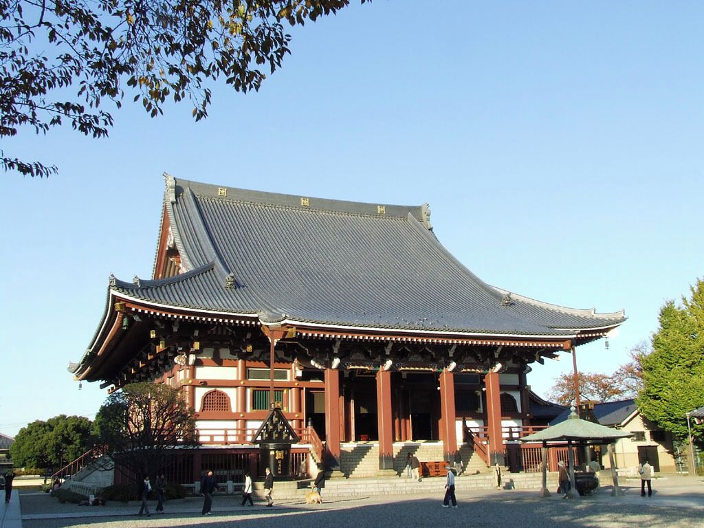 A traditional Japanese building with a curved roof and wooden pillars.